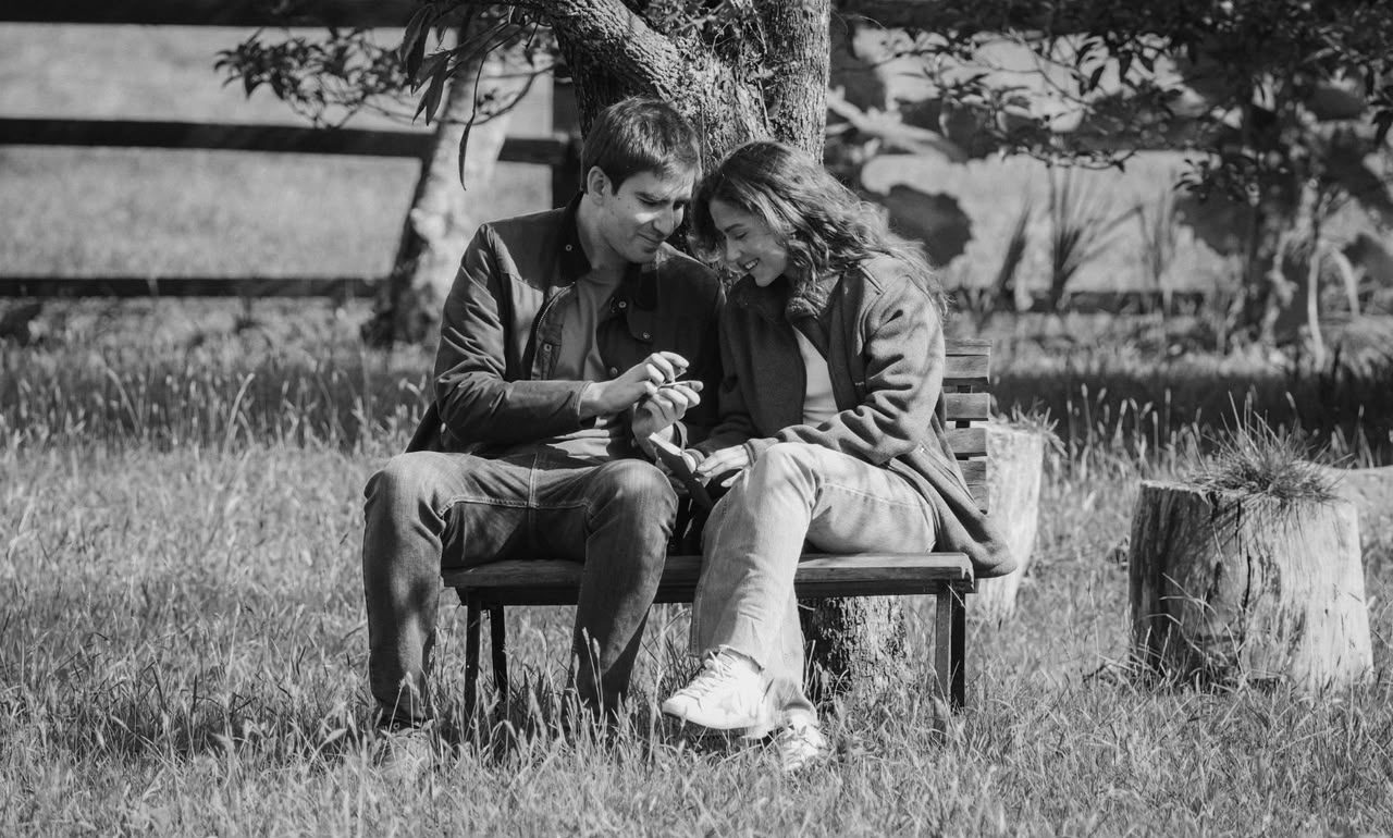 Paulina y Alberto mirando el anillo en una banca