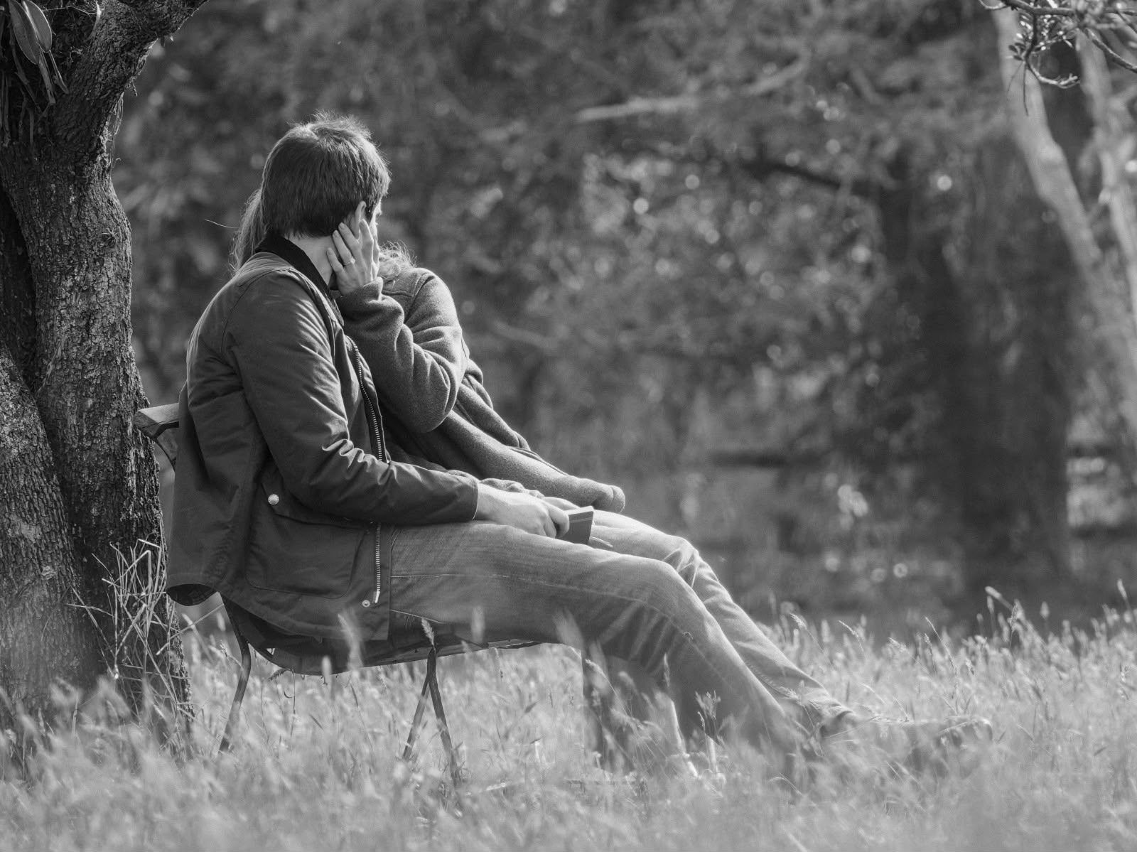 Paulina y Alberto sentados de espaldas en el campo